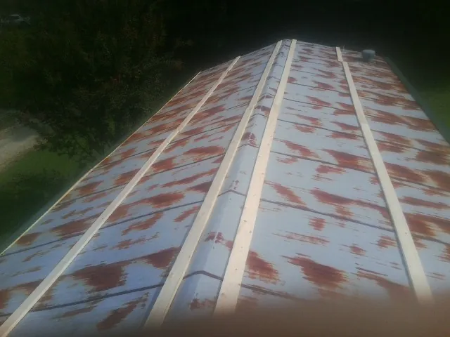Rusted metal roof panels with new wood purlins before replacement — Storm Damage Roof Repair in Clancy by Roofing Brothers